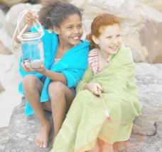 快乐小女孩沙滩岩石上快乐的小女孩图片