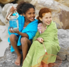快乐小女孩沙滩岩石上快乐的小女孩图片